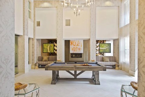 A billiard table is in the middle of a room with a pool table and a couch.