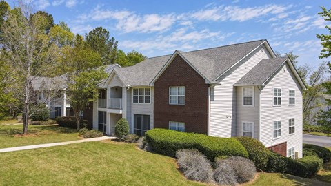 A large two-story house with a red brick exterior and white trim.