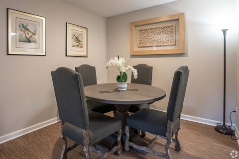 A dining room with a round table and four chairs.