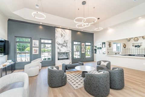 A modern living room with a large grey sofa and a round grey ottoman.