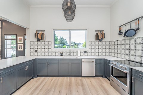 A kitchen with a white counter top and wooden floors.