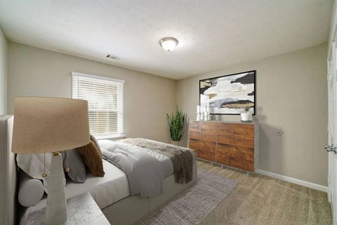 A bedroom with a bed, dresser, and a painting on the wall.