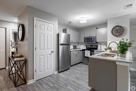 A kitchen with a stainless steel refrigerator, microwave, and oven.