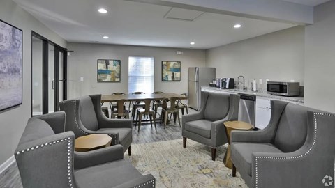 A living room with grey couches and a dining table.