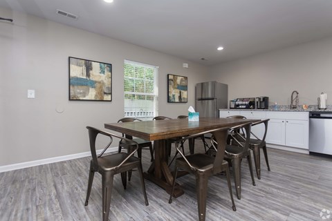 A dining room with a wooden table and chairs.