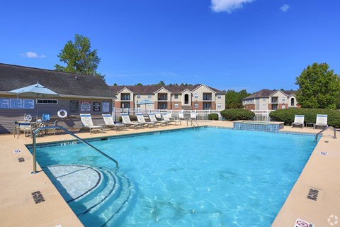 A large swimming pool with a slide and sun loungers.