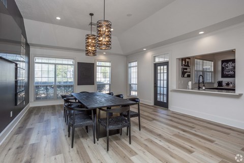 A modern dining room with a wooden table and chairs.