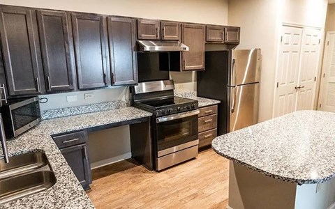 A kitchen with black cabinets and stainless steel appliances.