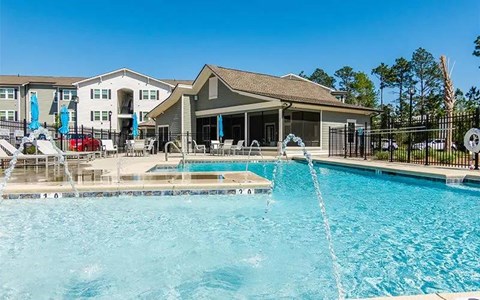 A swimming pool with a slide and a building in the background.