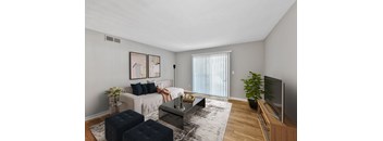 A living room with a white couch, a coffee table, and a television.