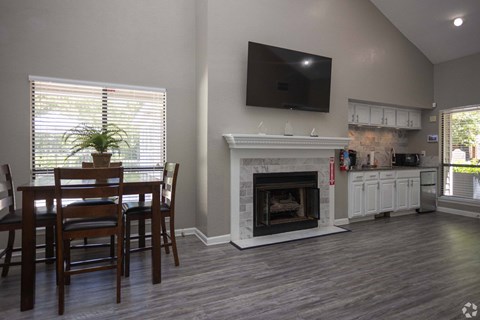A living room with a fireplace and a television mounted on the wall.
