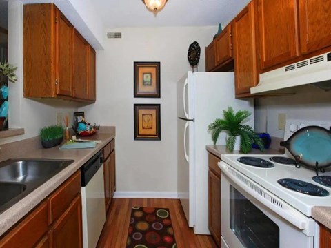 A kitchen with a white refrigerator and a white stove top oven.