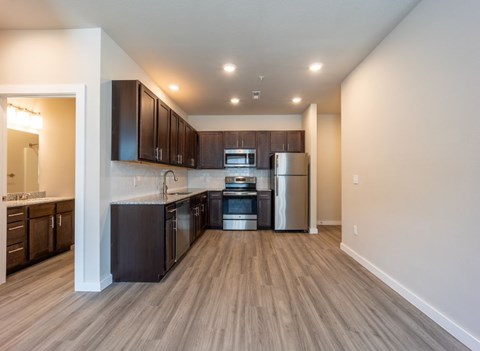 A modern kitchen with dark wood cabinets and stainless steel appliances.