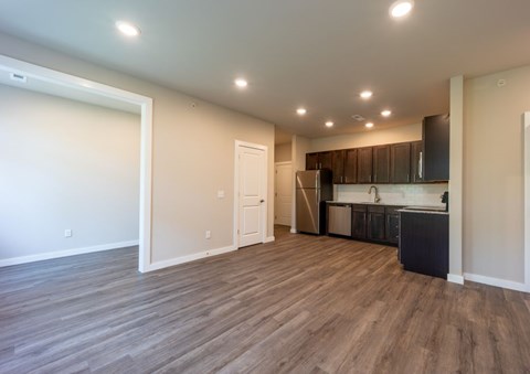 A kitchen area with a refrigerator, cabinets, and a countertop.