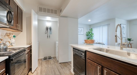 A modern kitchen with dark wood cabinets and a white countertop.