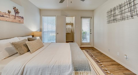 A bedroom with a large bed and a painting on the wall.