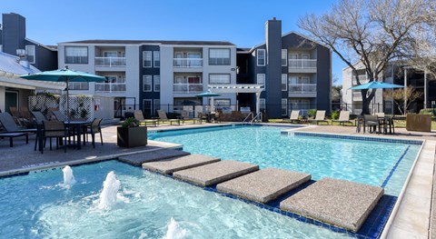 A pool with a fountain in the middle of it.