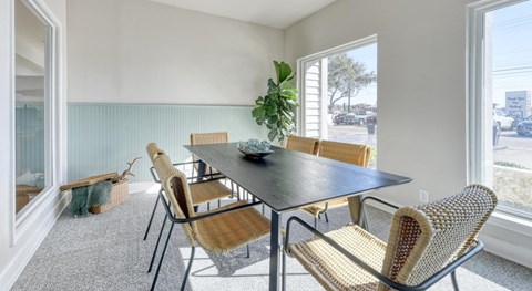 A dining room with a table and chairs.