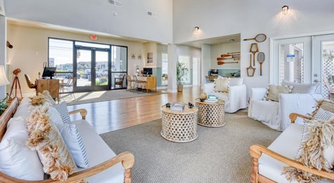 A living room with a white couch and a grey rug.