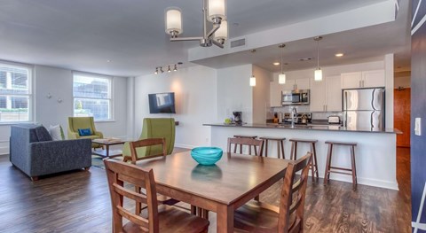 A modern kitchen and dining room with wooden floors and furniture.