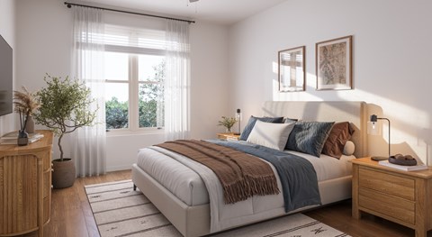 A bedroom with a large bed and a window with curtains.