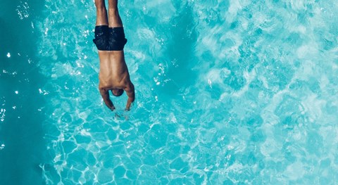 A person's hand is submerged in water.