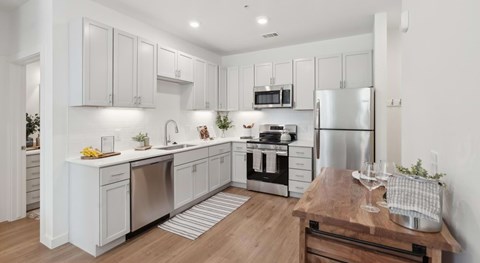 A modern kitchen with white cabinets and stainless steel appliances.