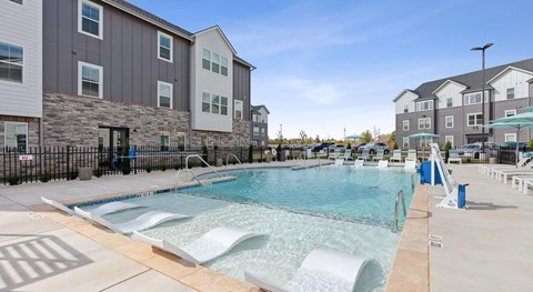 A swimming pool in front of apartment buildings.