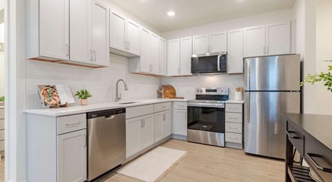 A modern kitchen with stainless steel appliances and white cabinets.