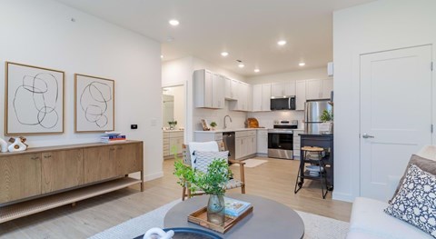 A modern kitchen with a dining table and chairs in the middle.
