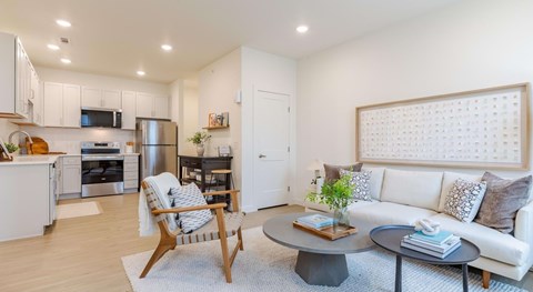 A modern living room with a white sofa and a wooden coffee table.
