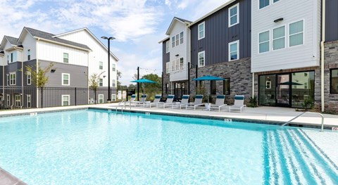 A swimming pool in front of apartment buildings.