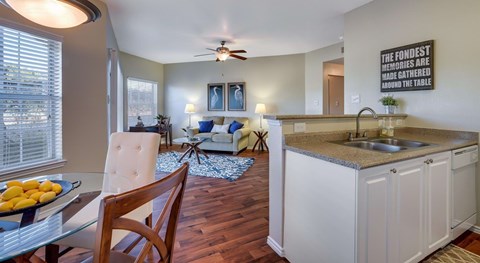 A kitchen with a dining table and chairs.