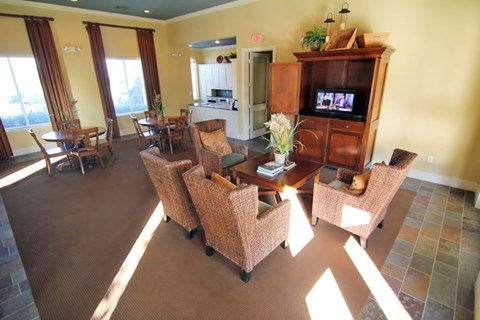 A living room with a brown sofa and chairs.