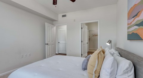 A bedroom with a large bed and a painting on the wall.