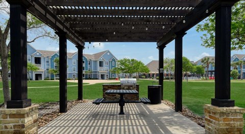 A wooden pergola with a bench underneath it.