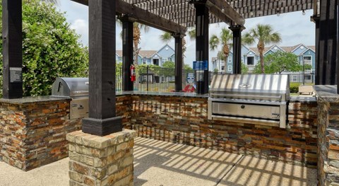 A brick pillar and a mailbox are in the foreground of a sunny day.