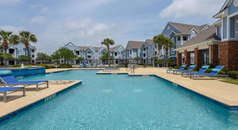 A large swimming pool in front of a row of houses.