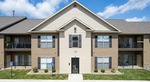 A two-story apartment building with a balcony on the second floor.