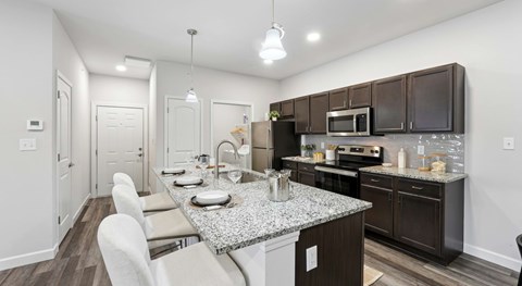 A modern kitchen with dark brown cabinets and a granite countertop.