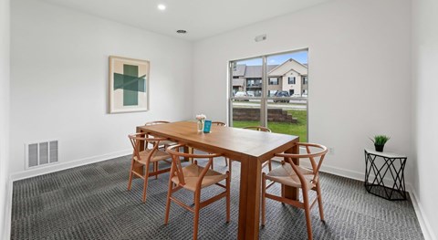 A dining room with a wooden table and chairs.