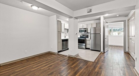 A kitchen with stainless steel appliances and wooden floors.