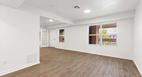 A room with wooden flooring and white walls.
