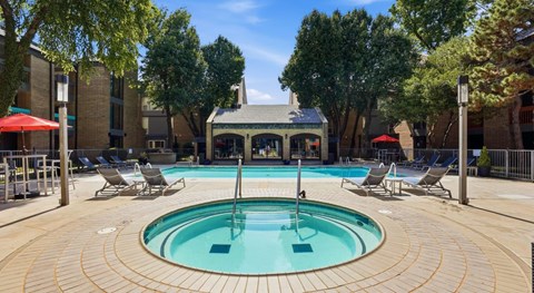 A pool surrounded by chairs and trees.