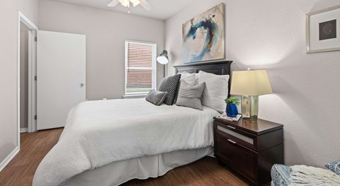 A bedroom with a large bed and a painting on the wall.