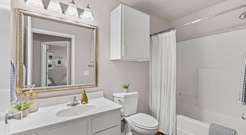 A white bathroom with a sink, toilet, and bathtub.