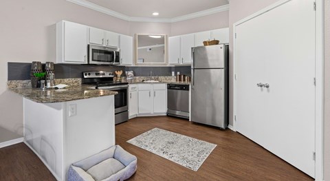 A kitchen with white cabinets and a granite countertop.