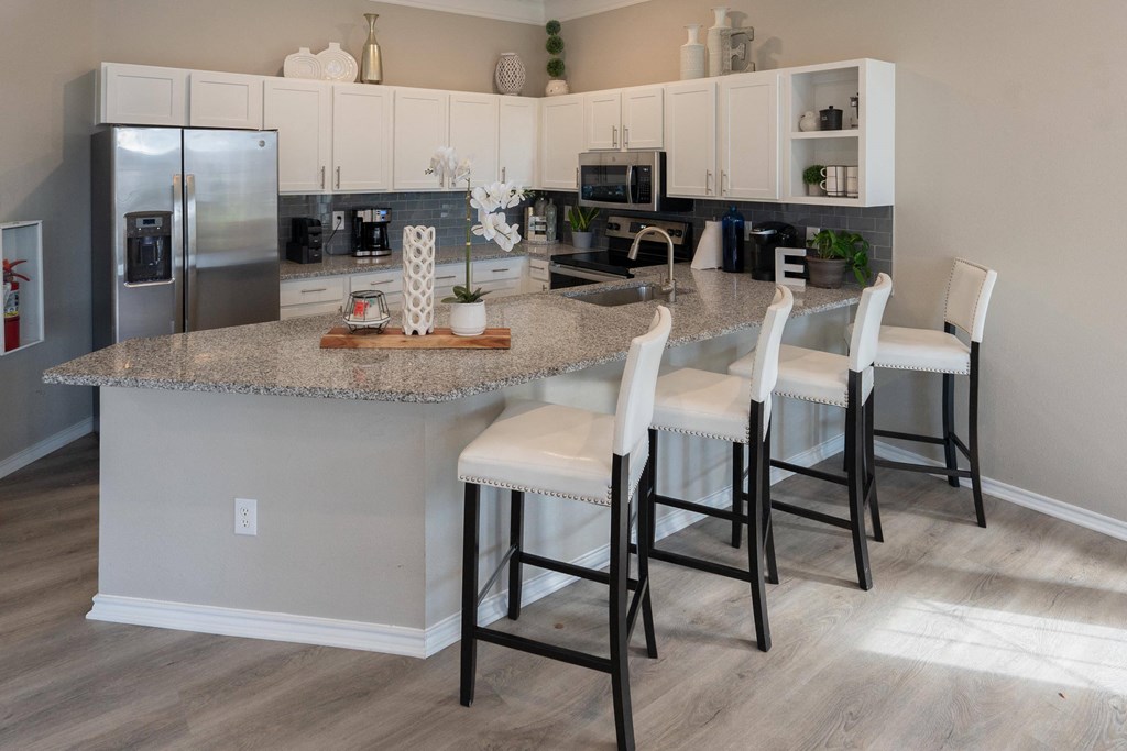 a kitchen with white cabinets and a granite counter top