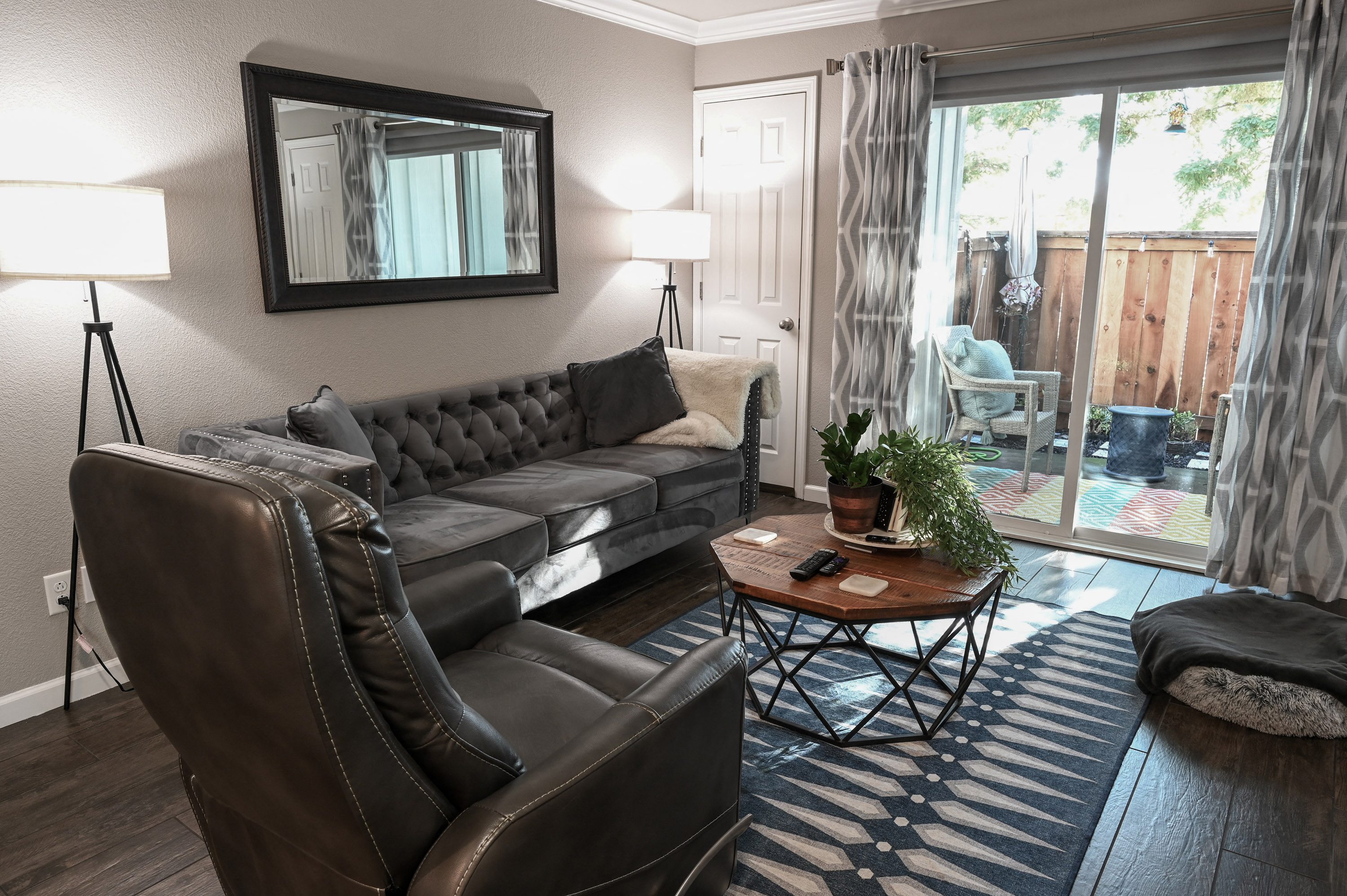 a living room with leather furniture and a sliding glass door to a patio