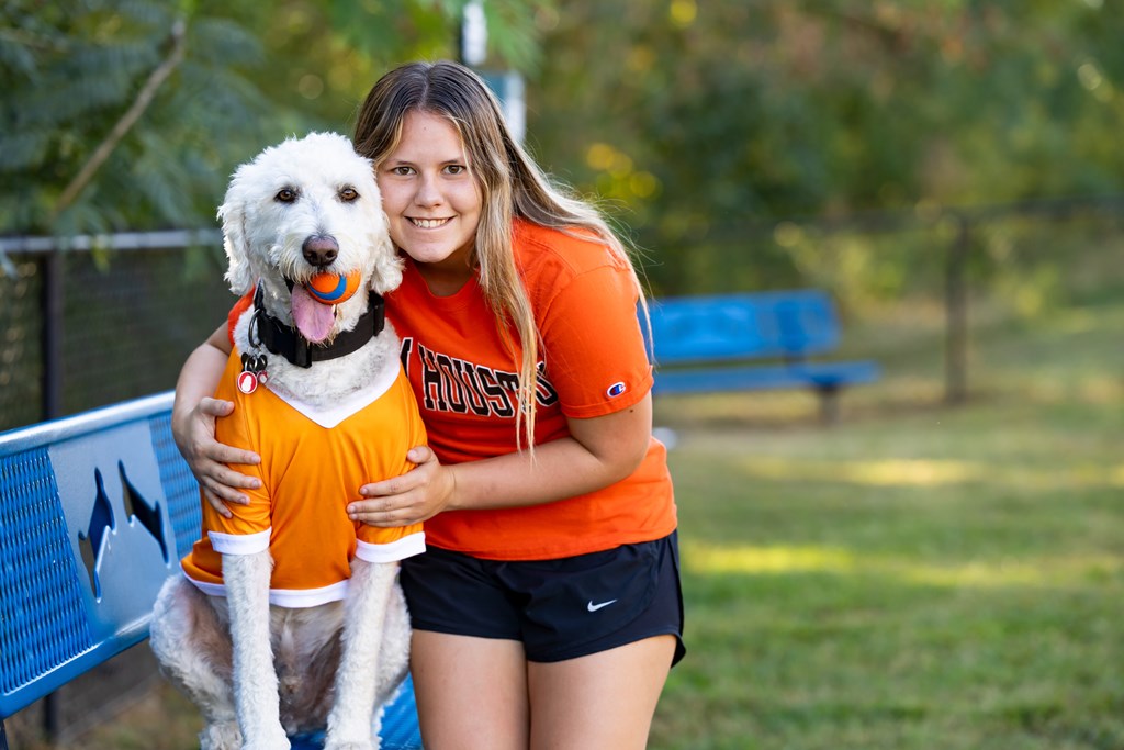 A woman is hugging a dog at Midtown Sam Houston Apartments, Huntsville, TX